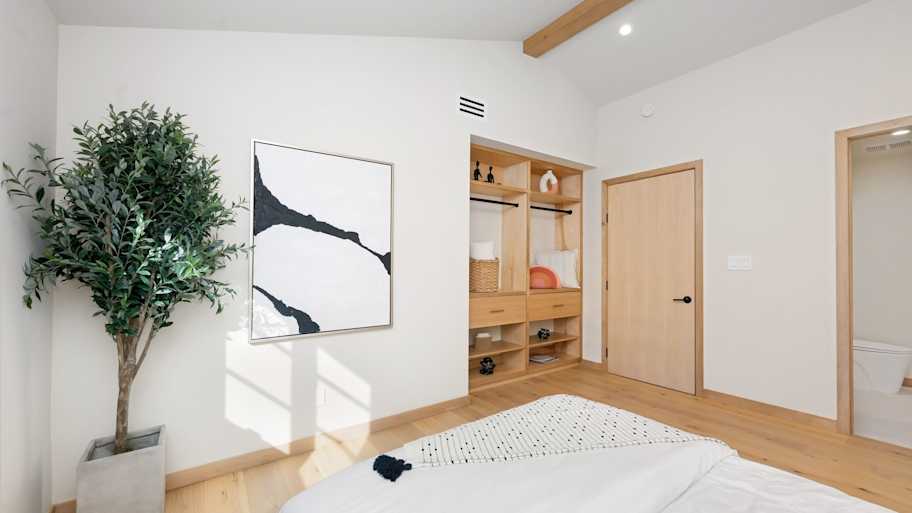 Scandinavian style bedroom with wooden baseboard and white walls