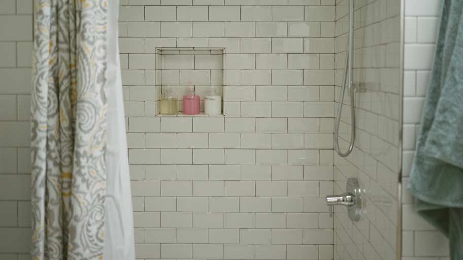 Tiled shower bathroom with green towel and soap